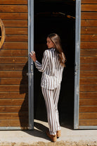 Back view of the adult brown stripe pajama top and pants.