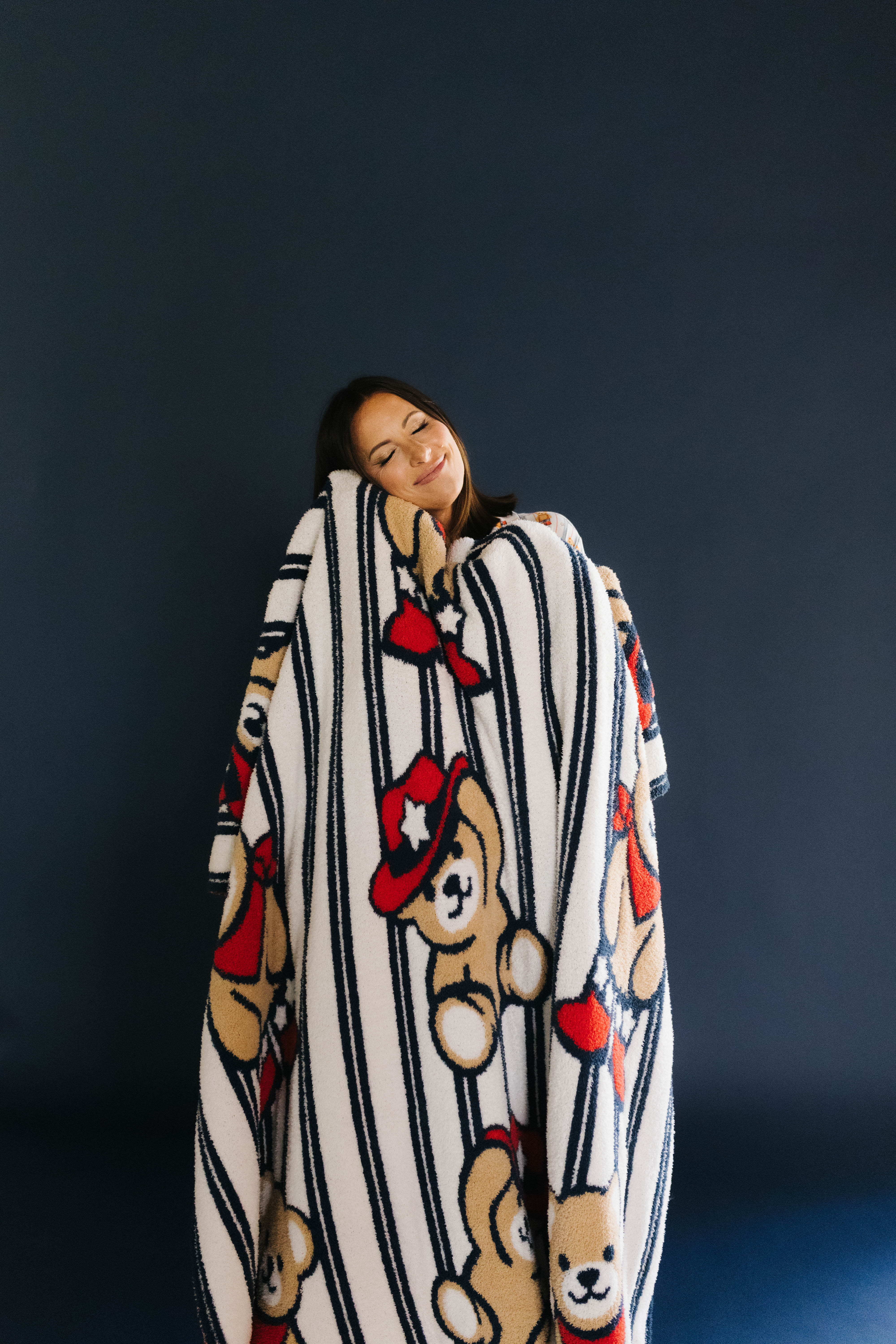 person with their face snuggled agains the teddy blanket