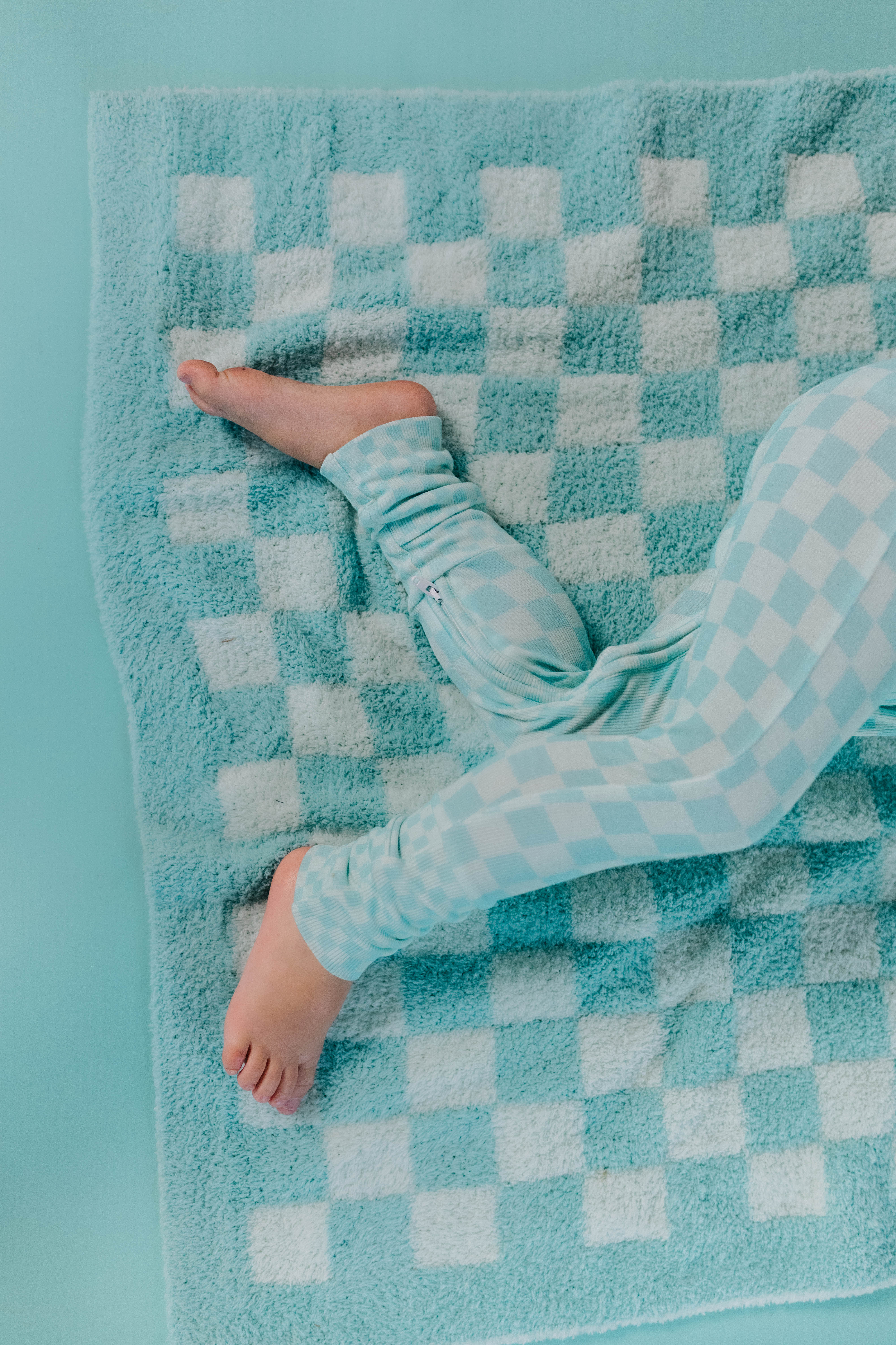 closer up detail of teal check blanket with kids legs 