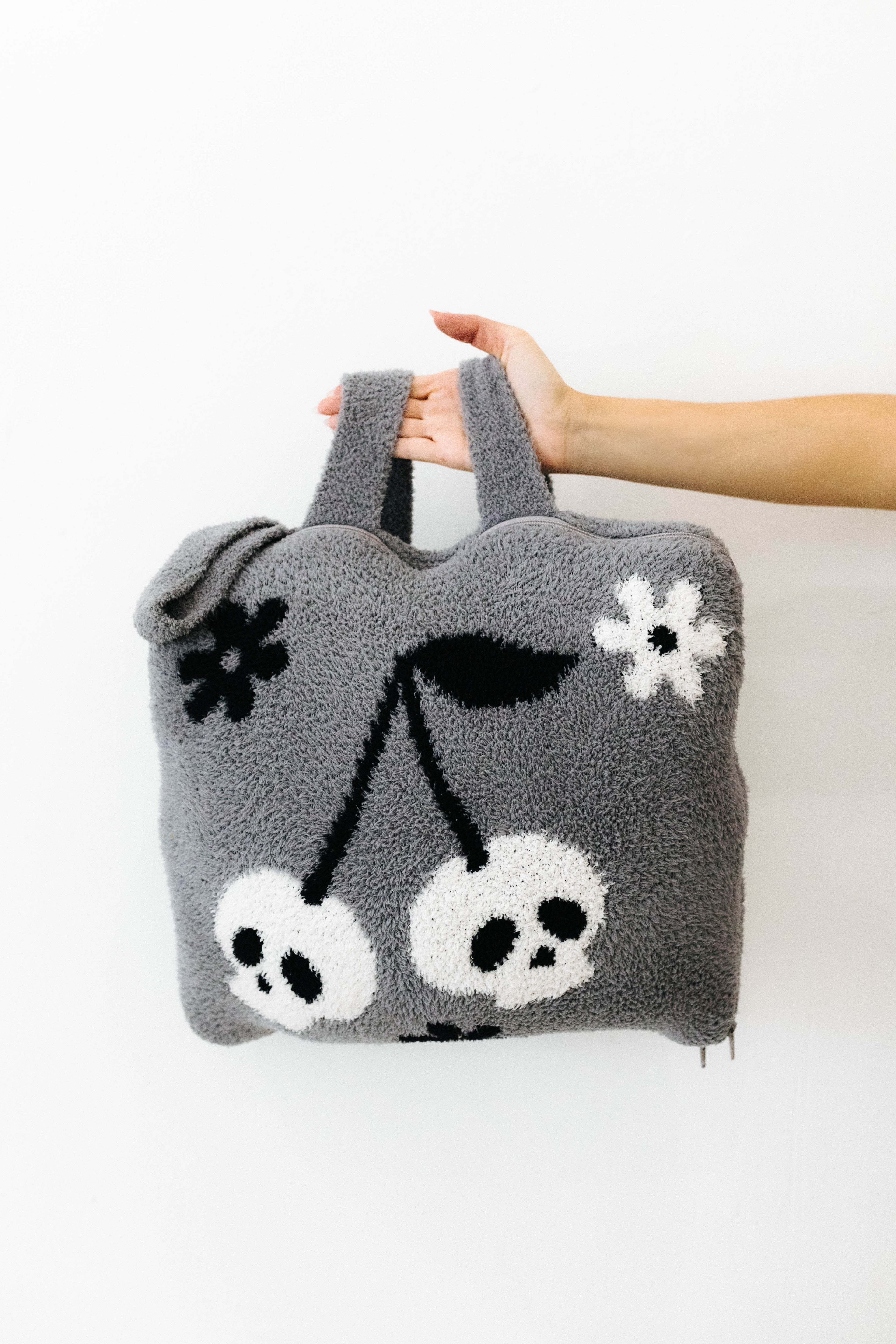 holding skelly backpack/wristlet quillow backpack straps in air 