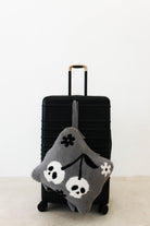 skelly backpack/wristlet quillow hanging on black suitcase