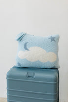 cloud backpack/wristlet quillow sitting on suitcase