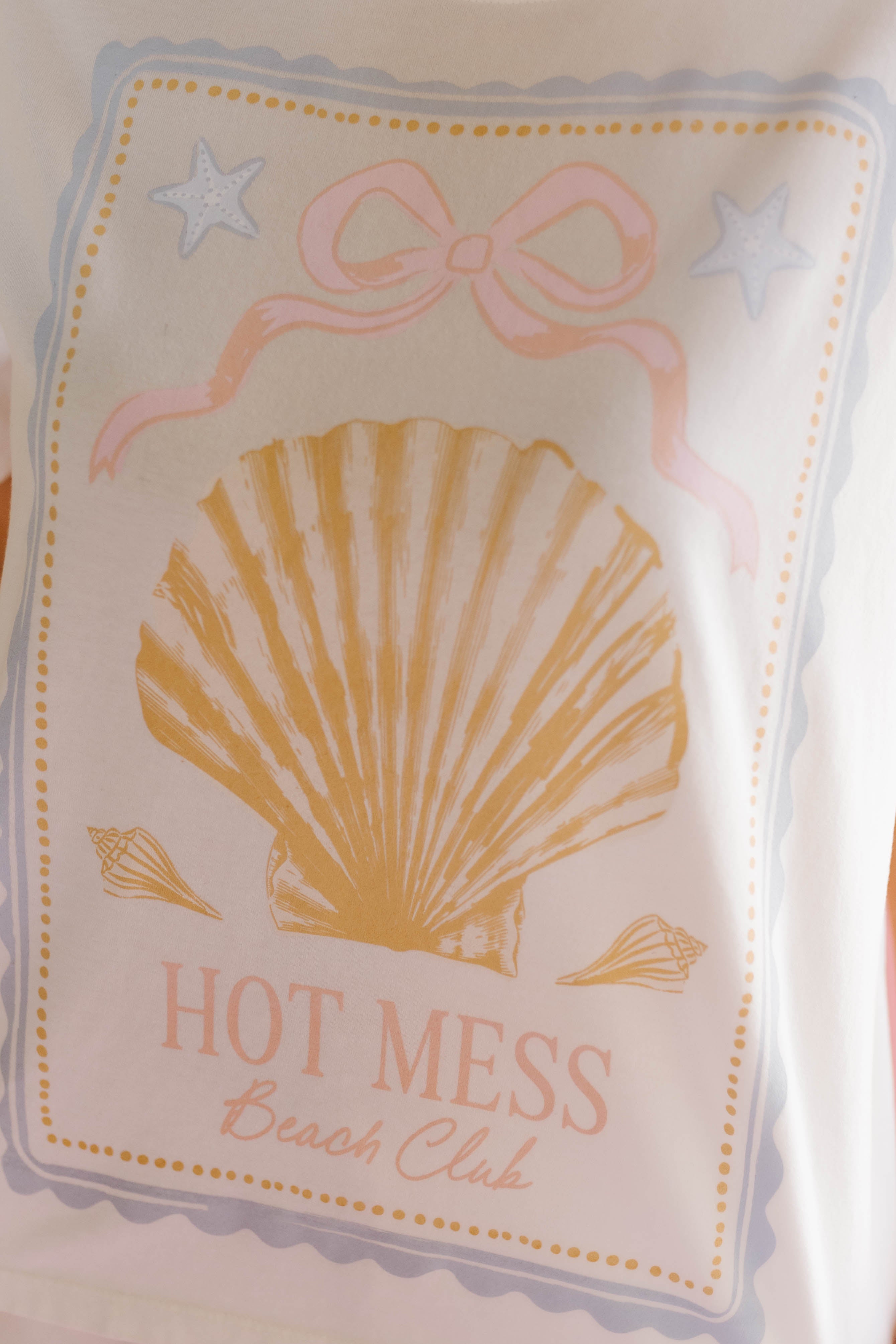 Product packaging with a shell design and 'Hot Mess Beach Club' text on a light background.