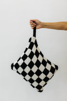 model holding wristlet of black check quillow