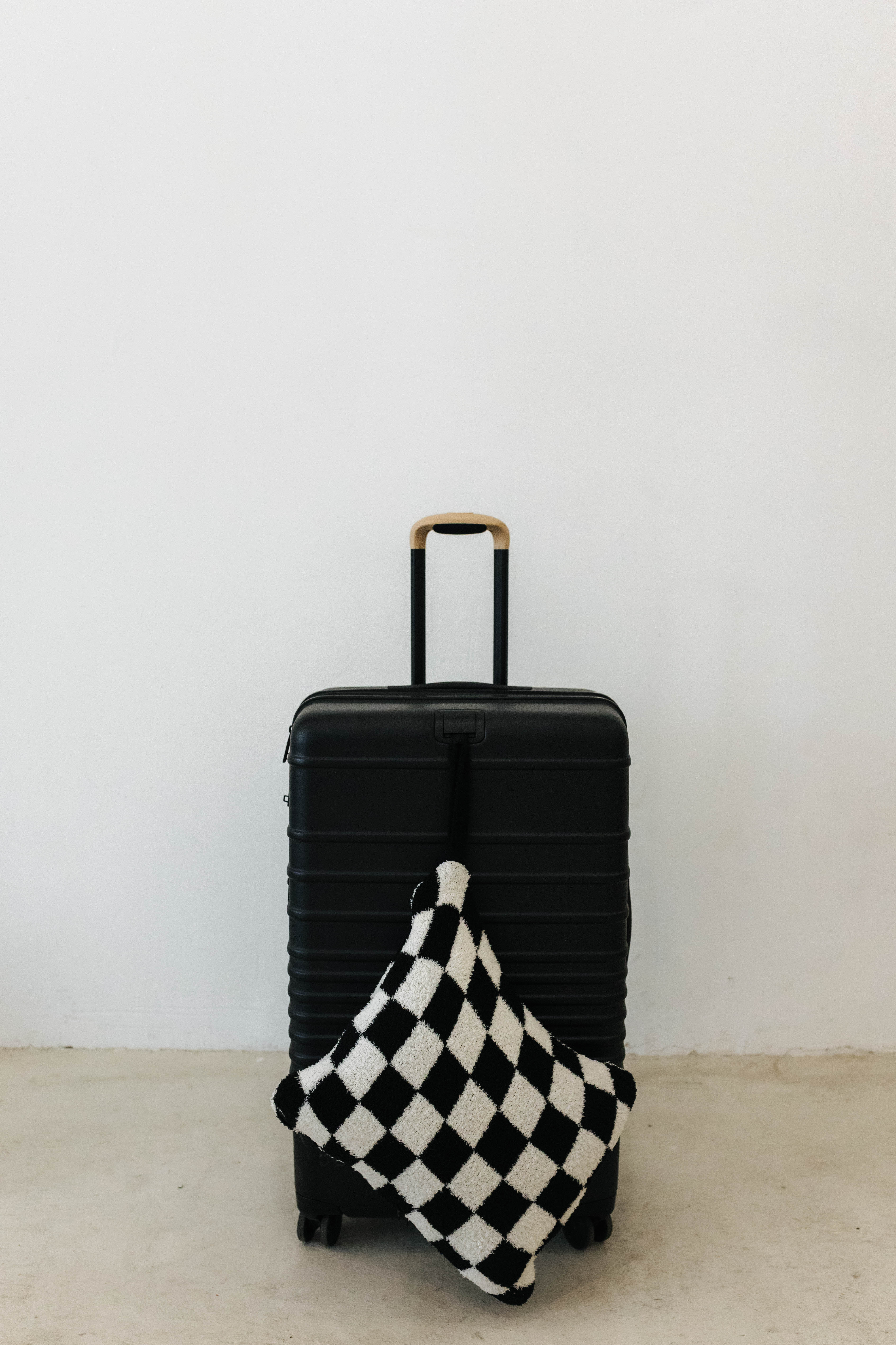 black check quillow hanging from black suitcase