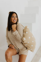 model krista smiling wearing lace polka dot pajamas and polka dot backpack quillow on shoulder 