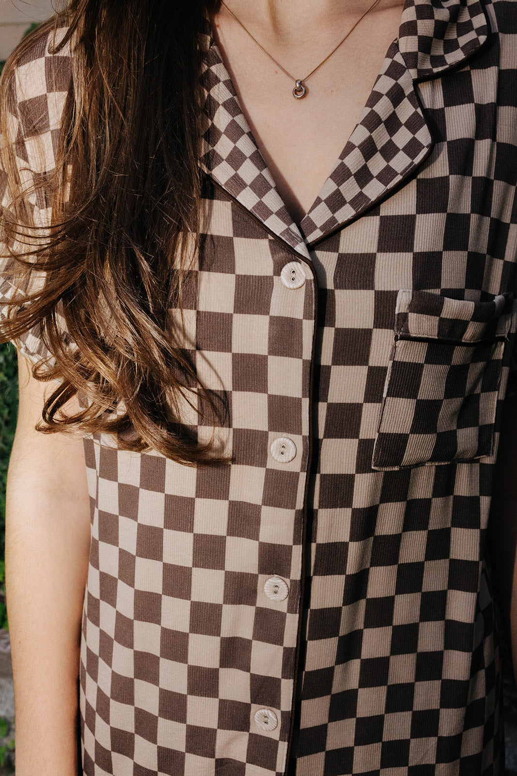 Close view of the brown check pajama shirt collar and buttons.