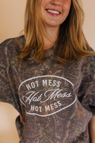 close up of hot mess tee detail with camo background 