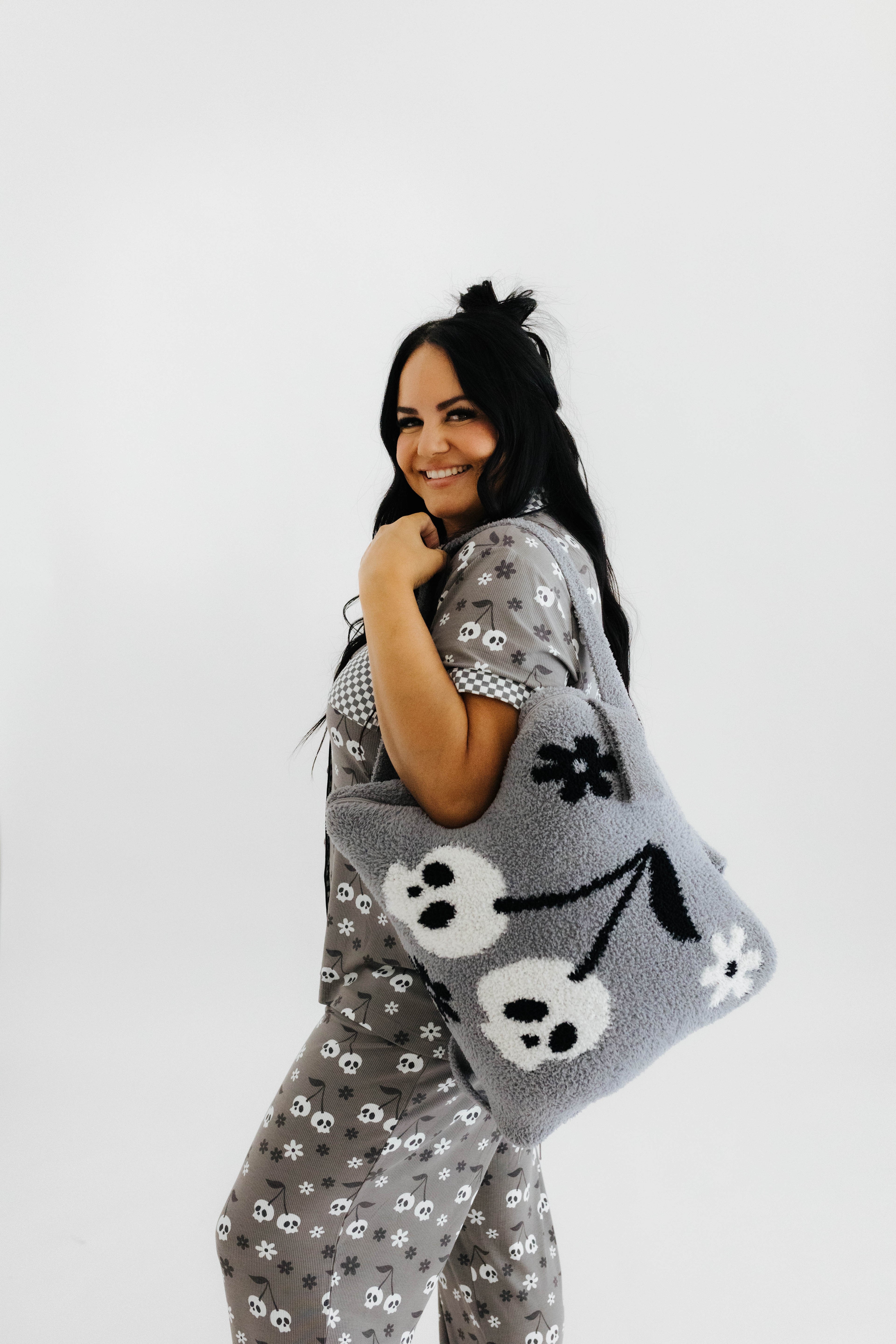 model regina wearing skelly backpack/wristlet quillow over shoulder 