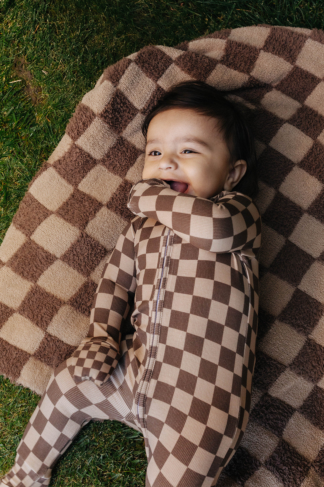 Baby wrapped in a brown check kids blanket.