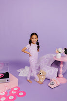Young girl on purple background with toys and decor