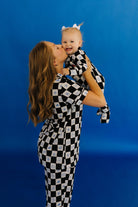 Woman and child in checkered pjs against a blue background