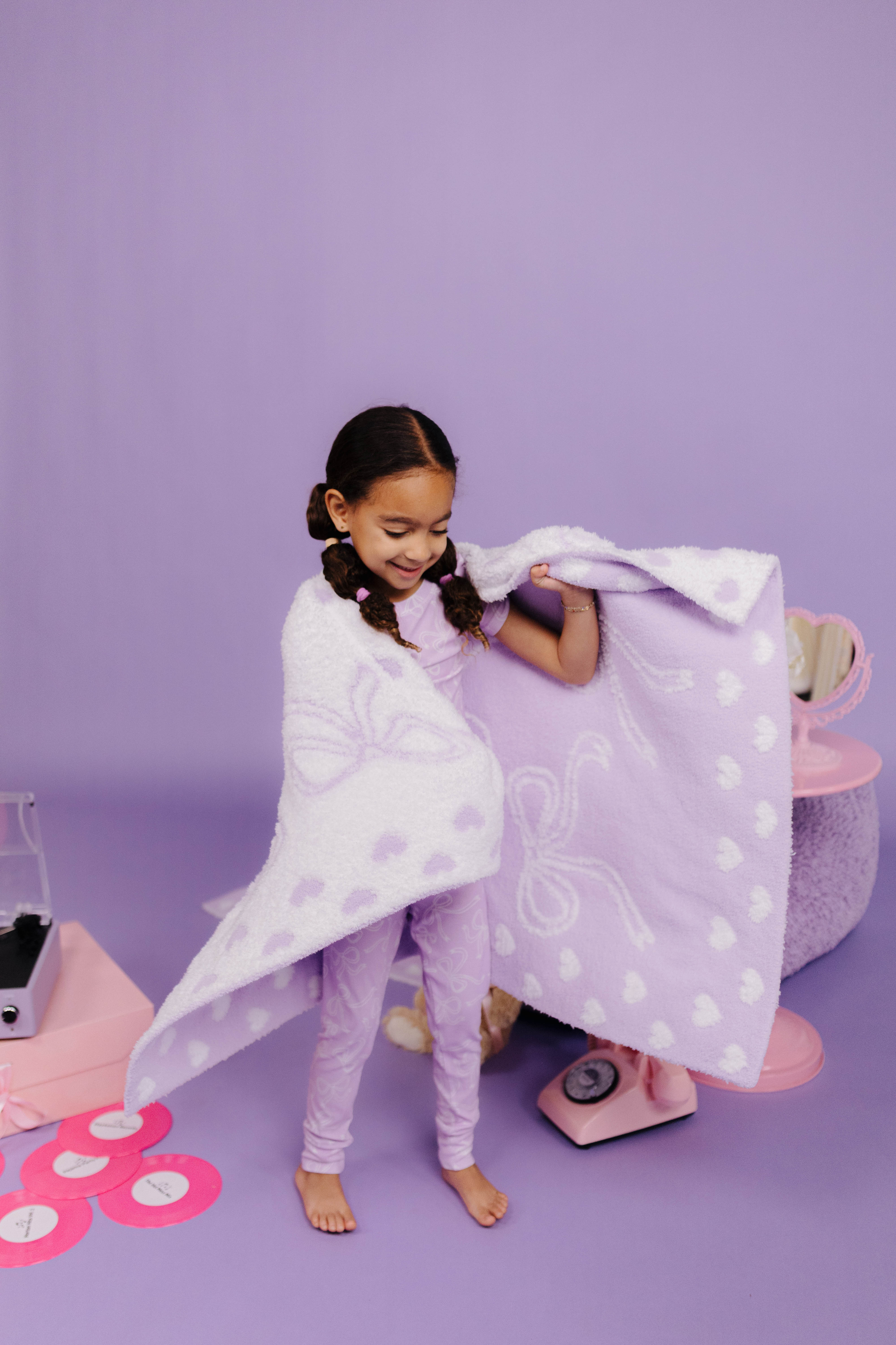 child wrapped in purple bow blanket