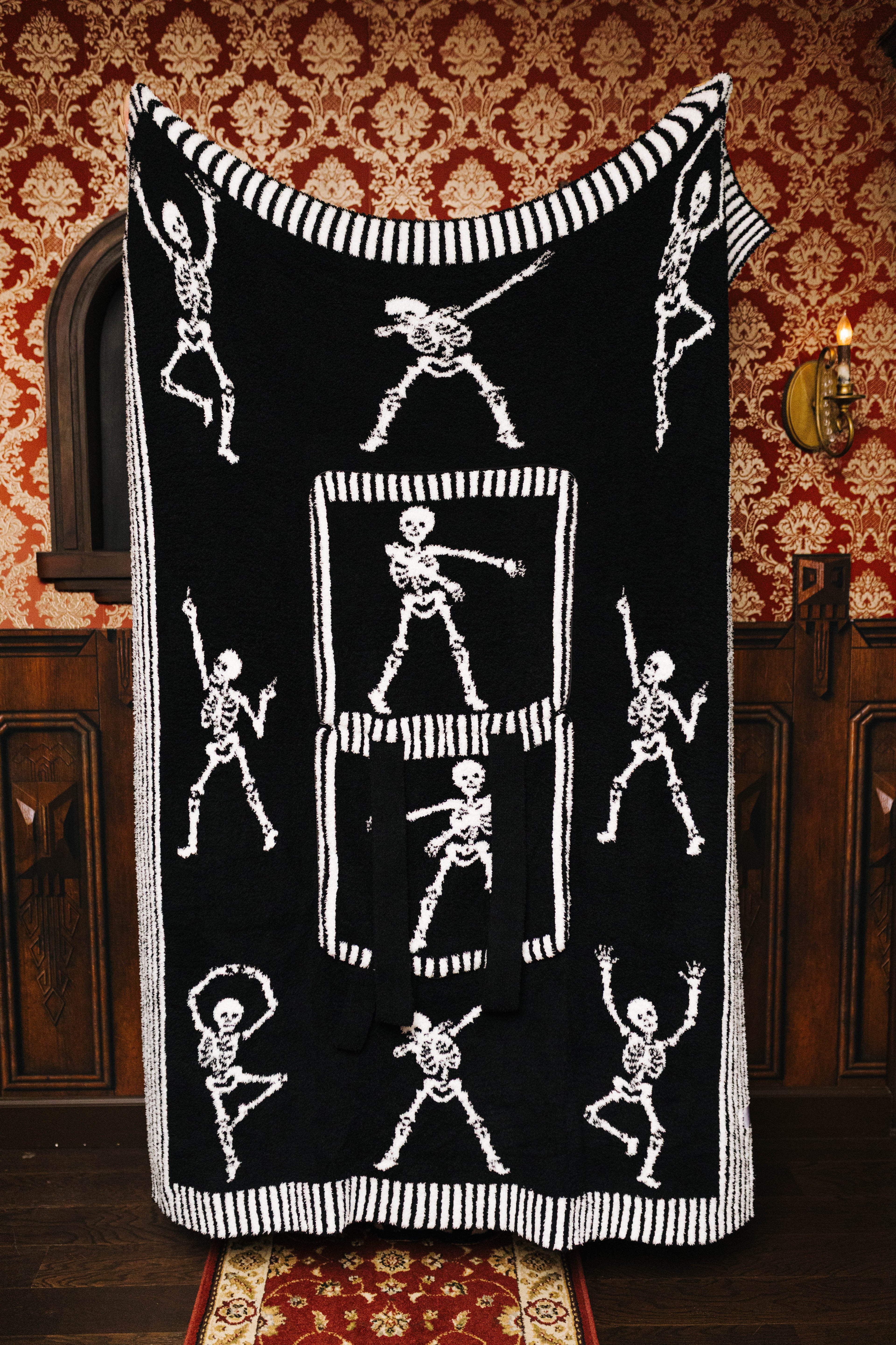Skelly quillow unfolded to show the black skeleton side