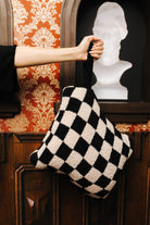 Sand and black check quillow held by its wristlet