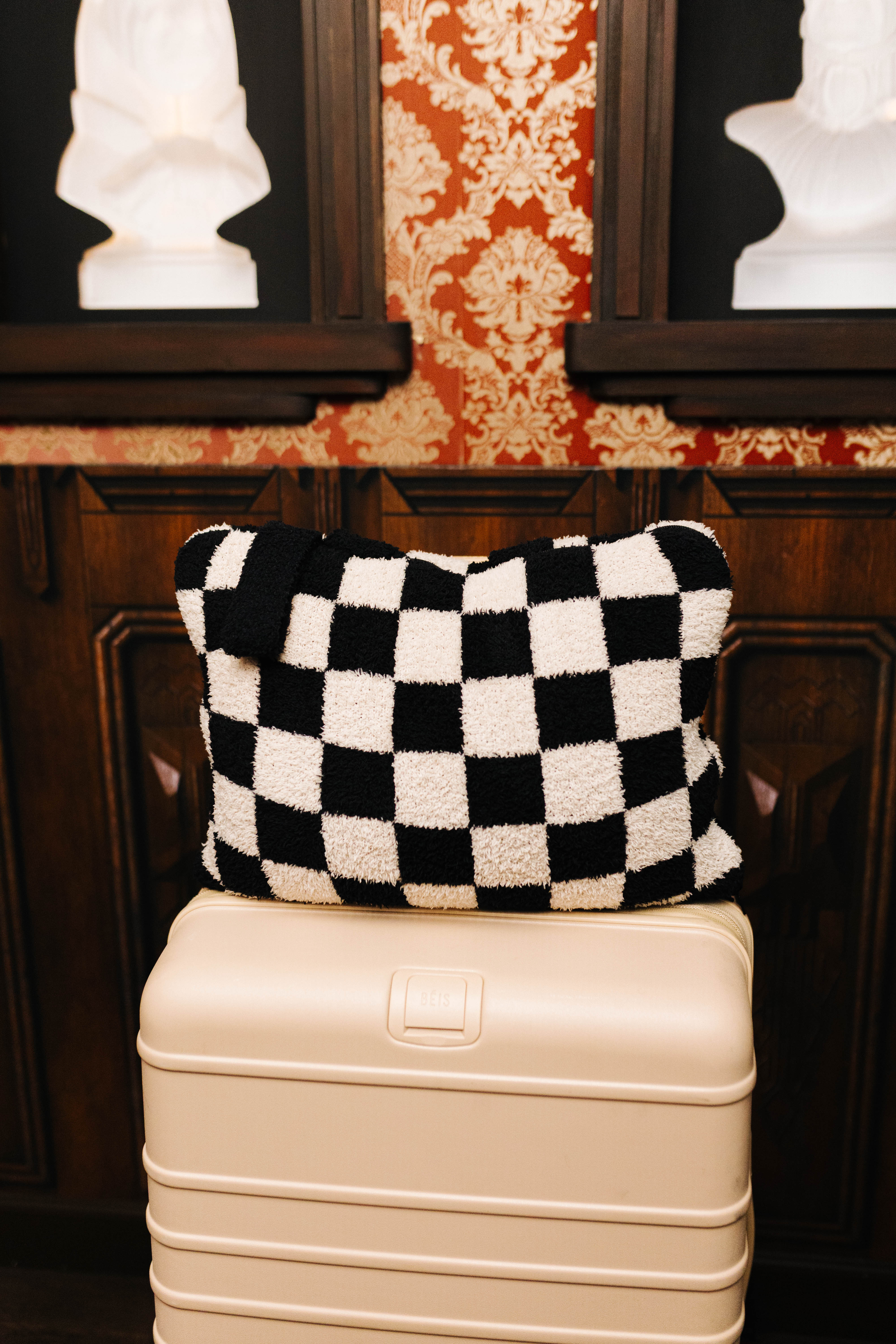 Sand and black check quillow folded on a suitcase
