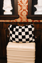 Sand and black check quillow folded on a suitcase