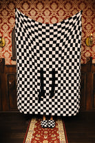 Sand and black check quillow unfolded as a blanket