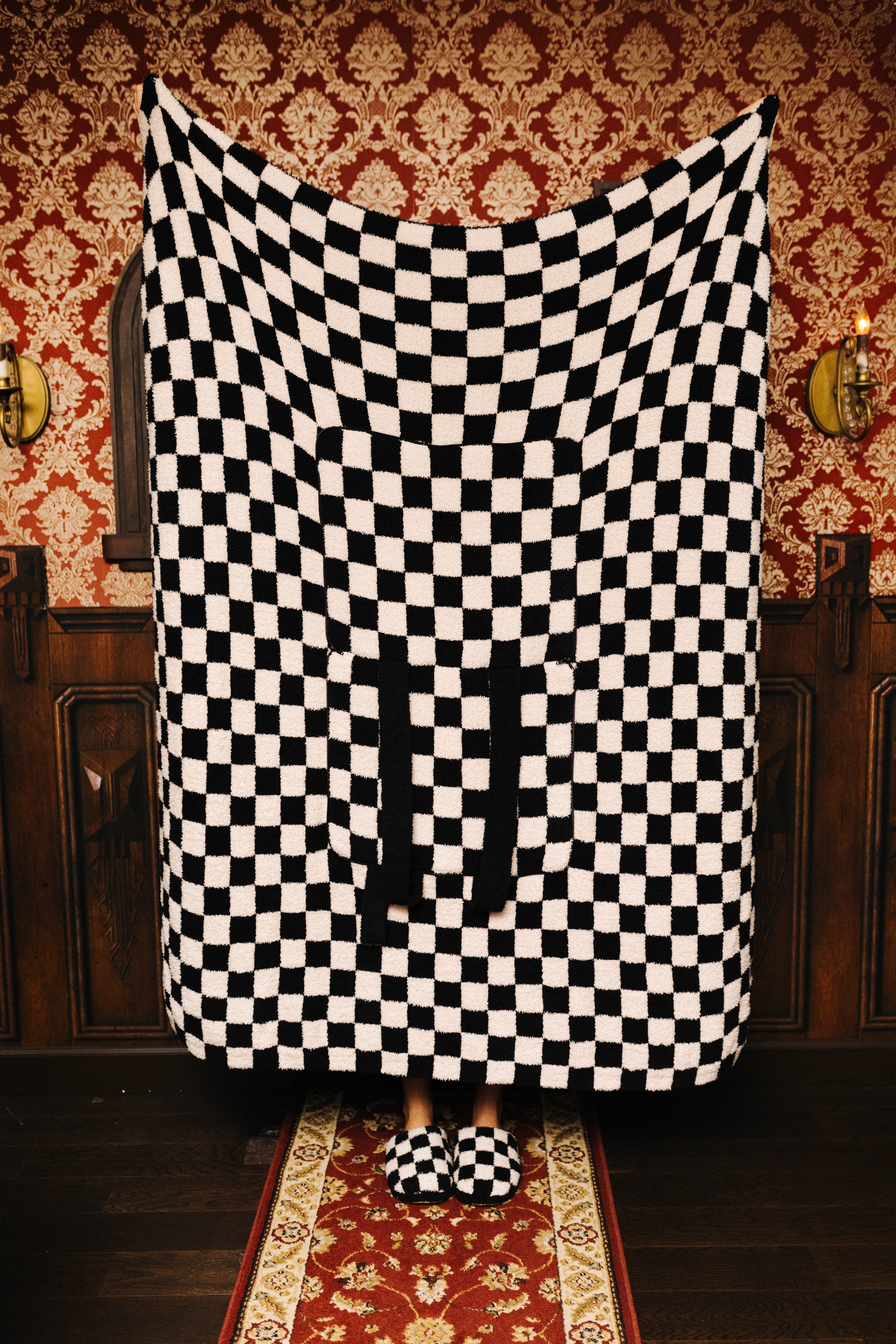 Sand and black check quillow unfolded as a blanket
