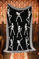 Skelly blanket held open to show the black skeleton side