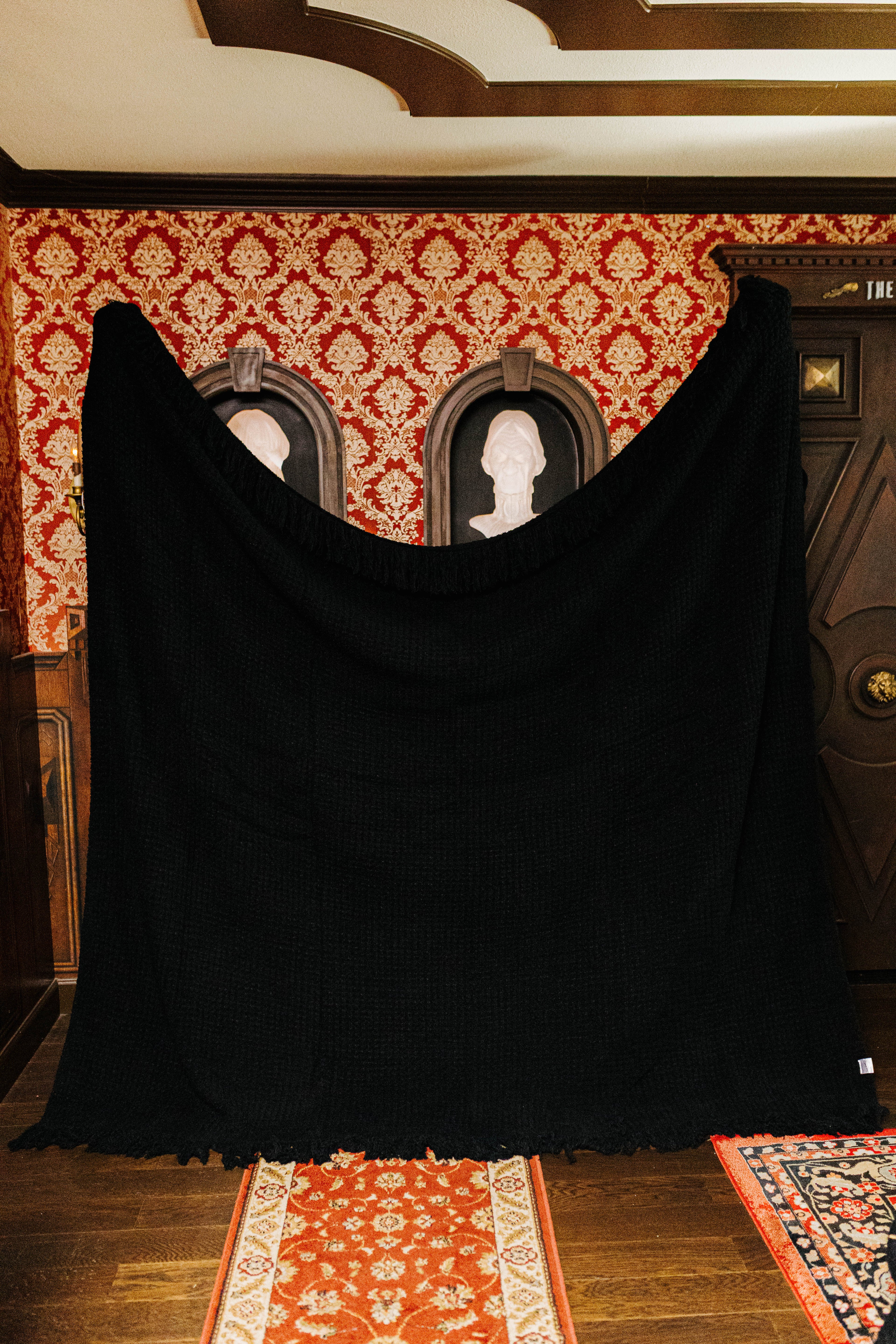 Black waffle fringe blanket held open to show its full size