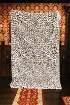 Leopard faux fur blanket held open to show the full print