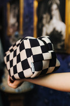 Side view of the sand and black check cosmetic bag