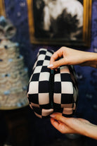 Sand and black check cosmetic bag showing its zipper