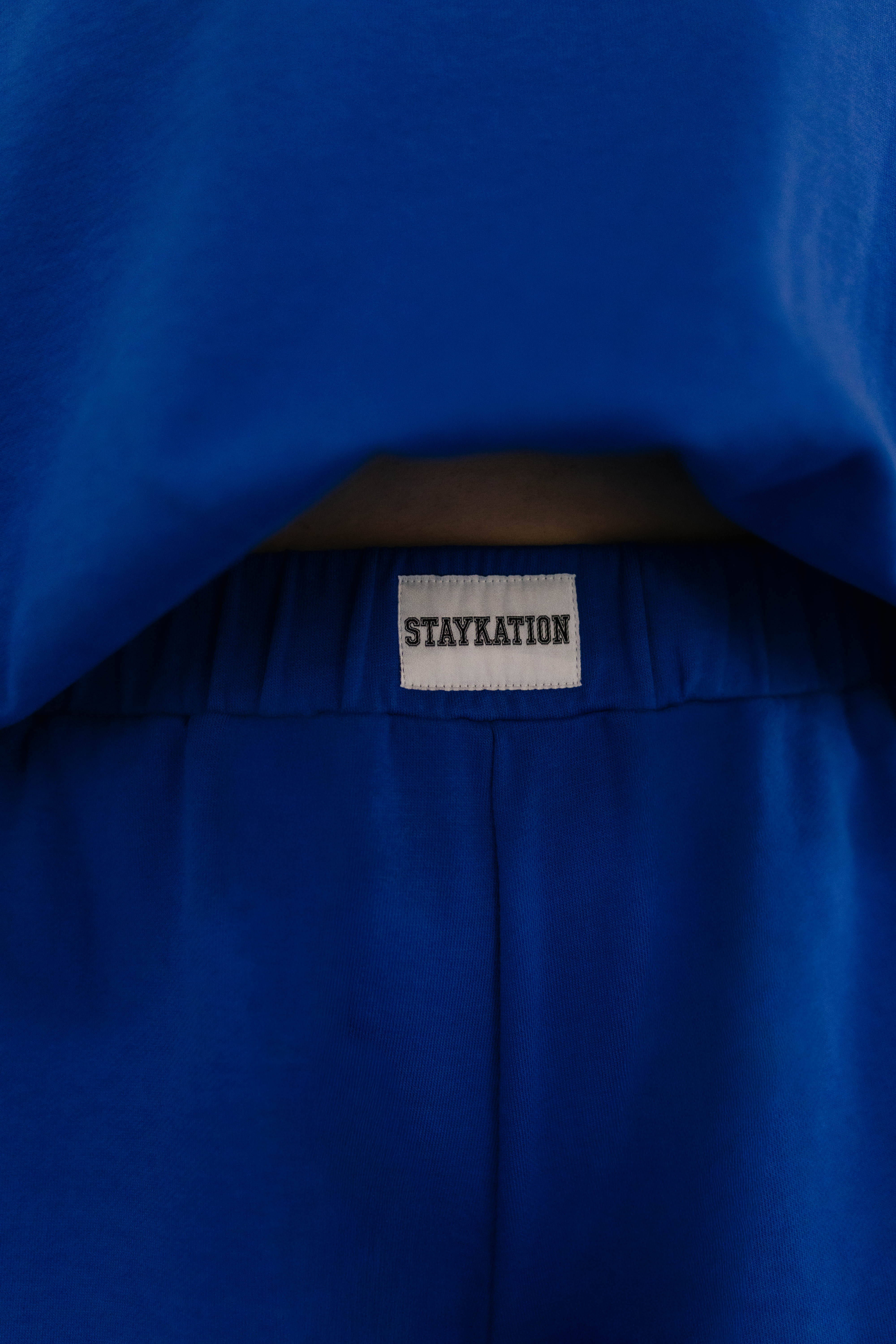 Showing the Staykation logo on the front of the shorts 