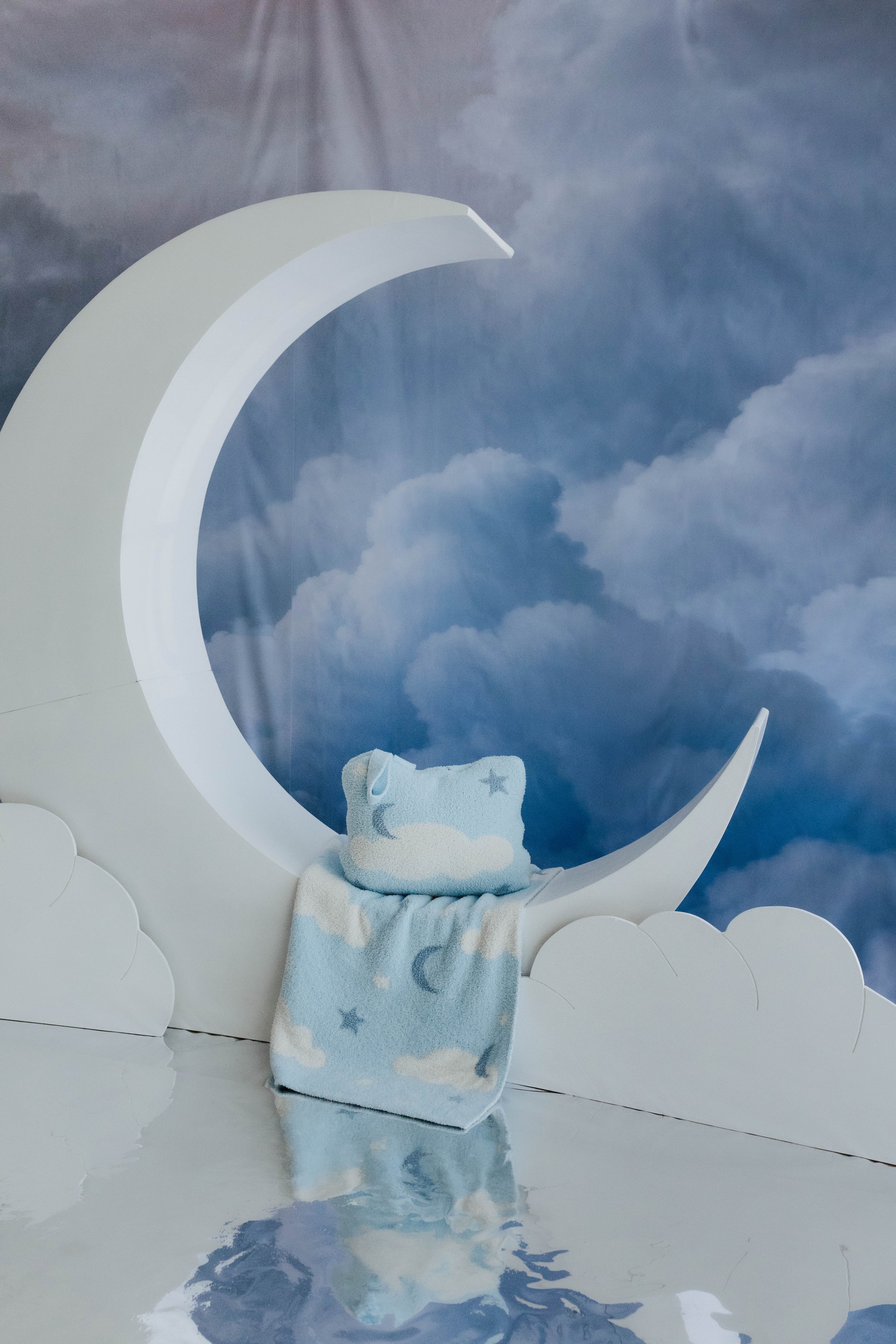 cloud backpack/wristlet quillow and cloud baby blanket sitting on moon decorations 