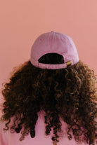 Person wearing a pink hat with a pink background