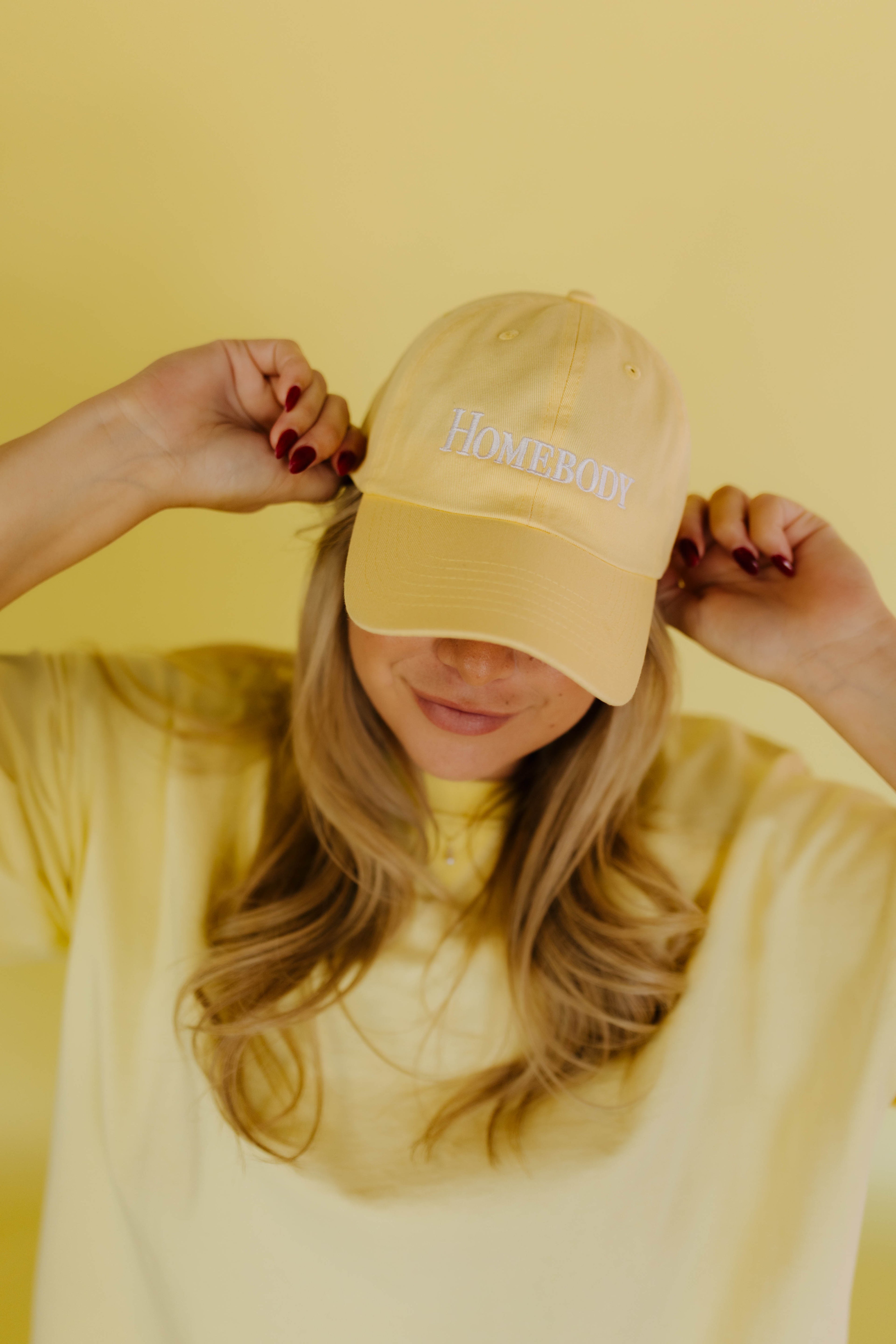 Yellow dad hat that says homebody 
