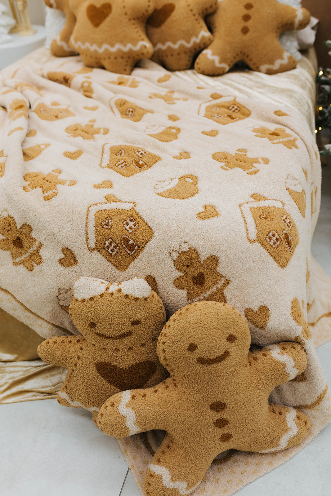Gingerbread-themed blanket with gingerbread men and houses on a white surface.