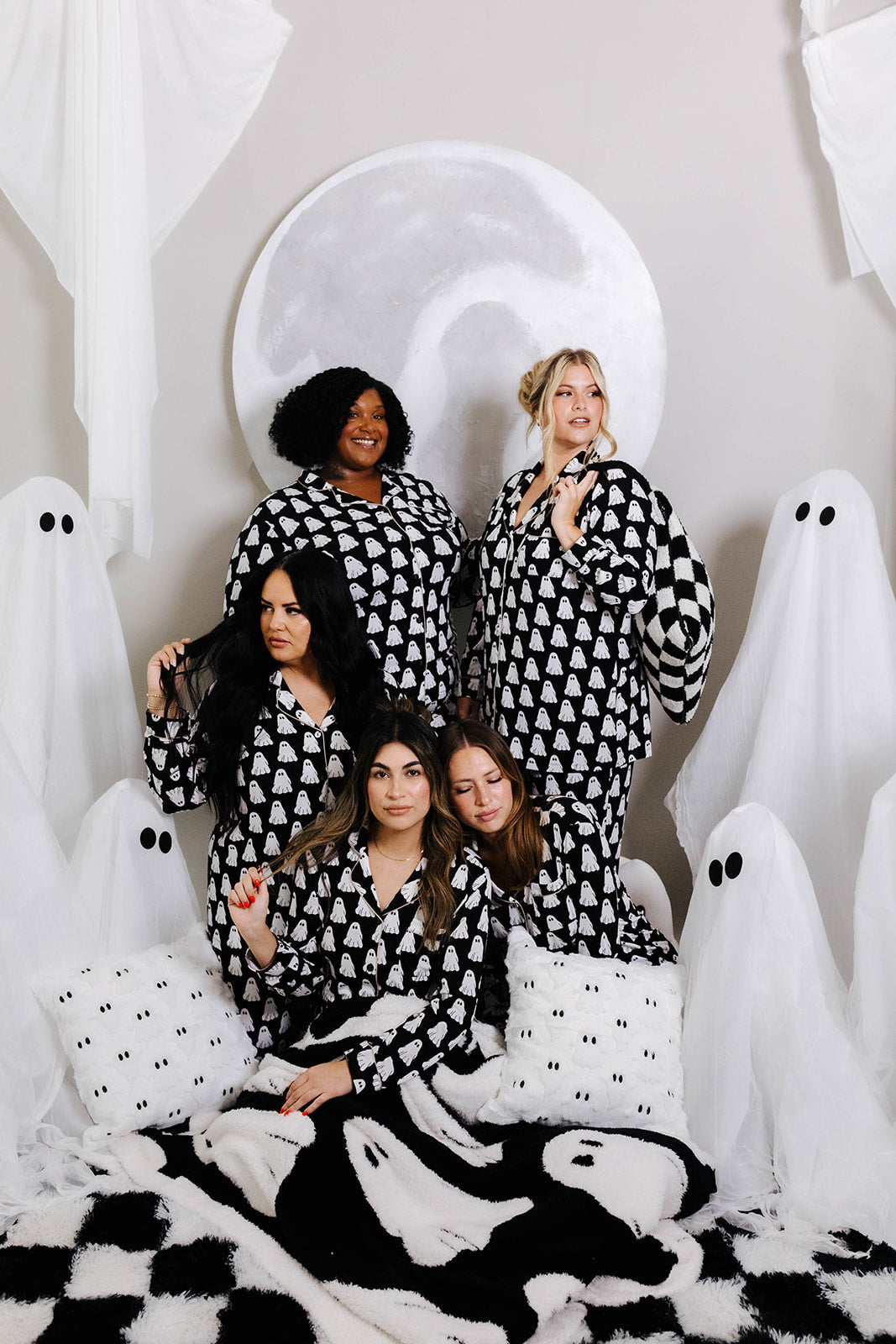 all models looking away wearing ghost pajamas with ghost decorations in background