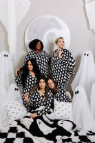 all models looking away wearing ghost pajamas with ghost decorations in background