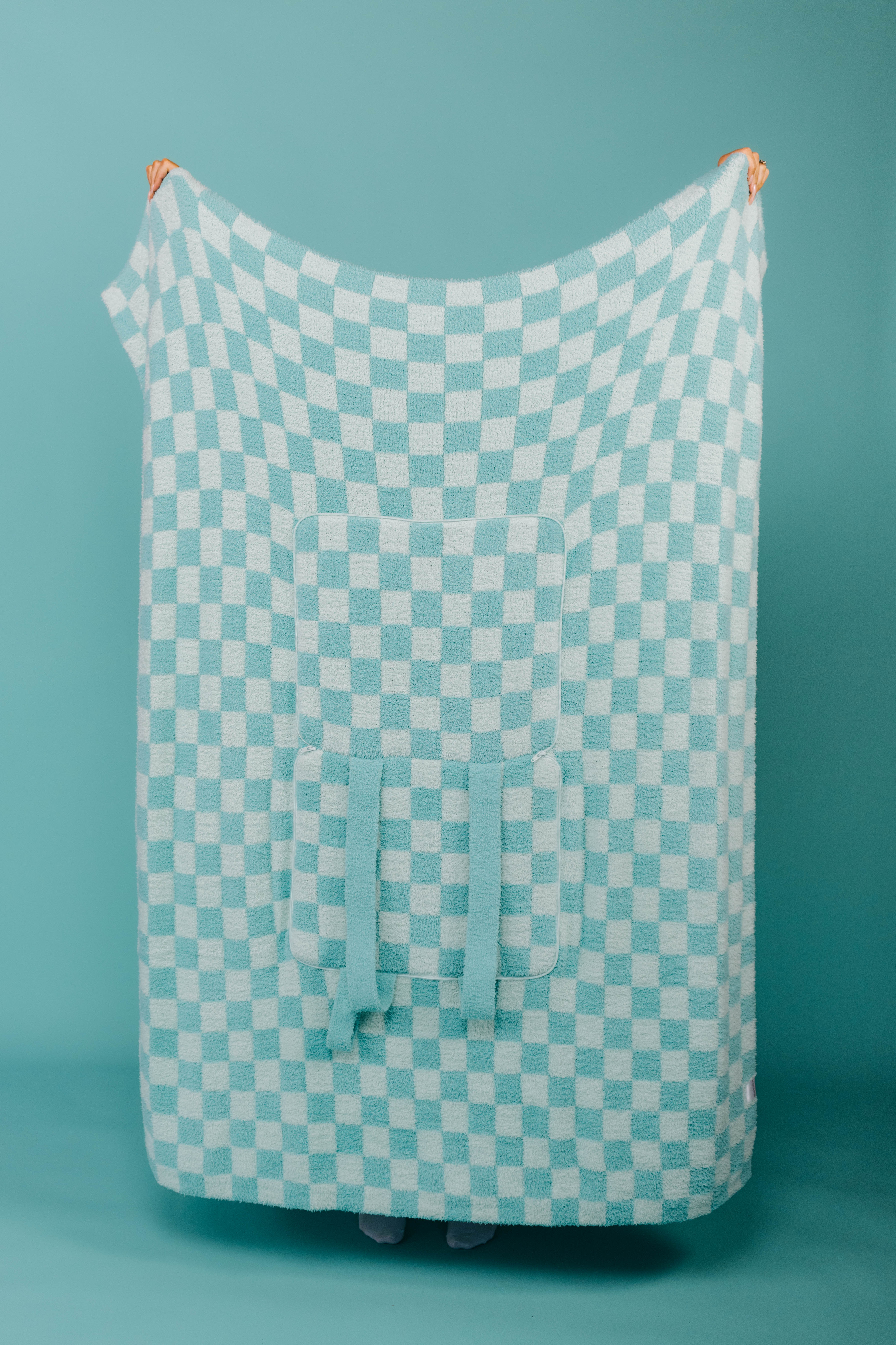 Holding up the teal check quillow 