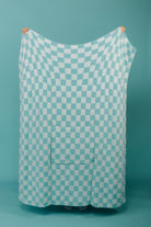 holding the teal check quillow showing the back