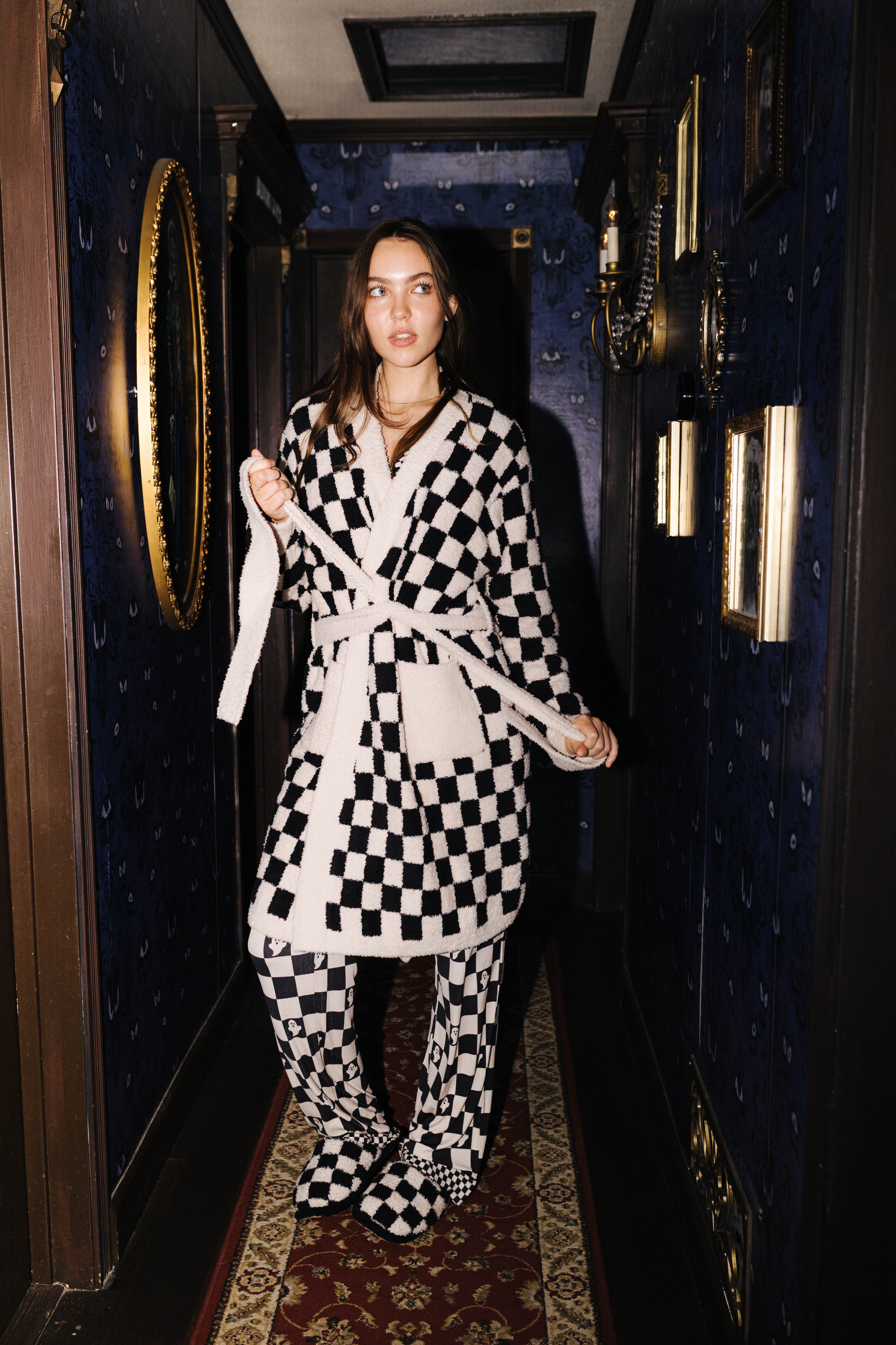 Front view of the sand and black check fluffy robe on a model