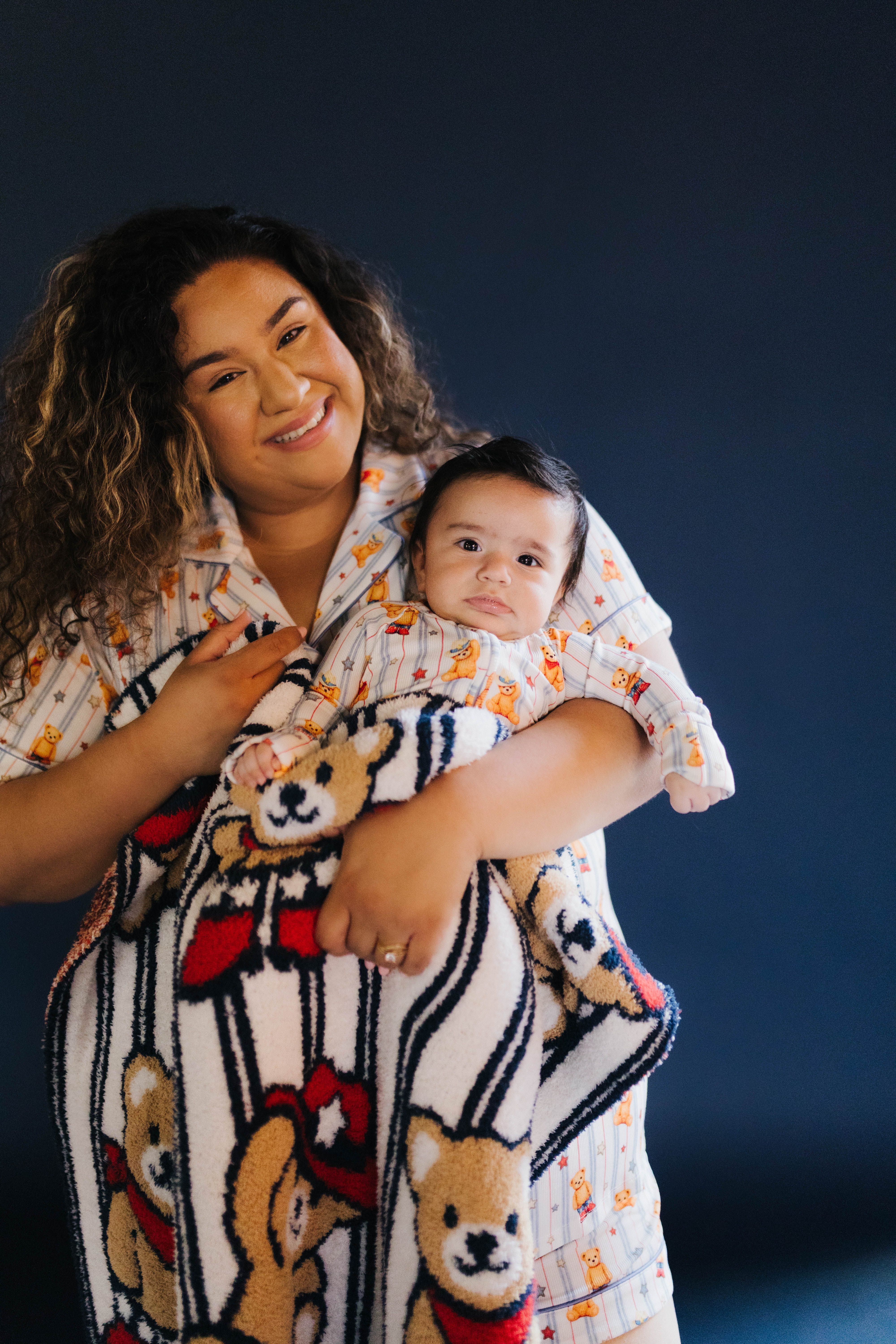 Woman holding baby and the baby wrapped in the teddy blanket
