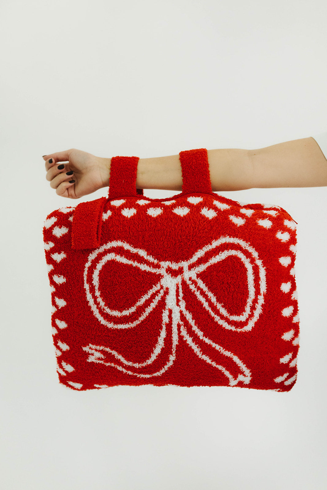 Red quillow with a white bow design held by a person against a white background