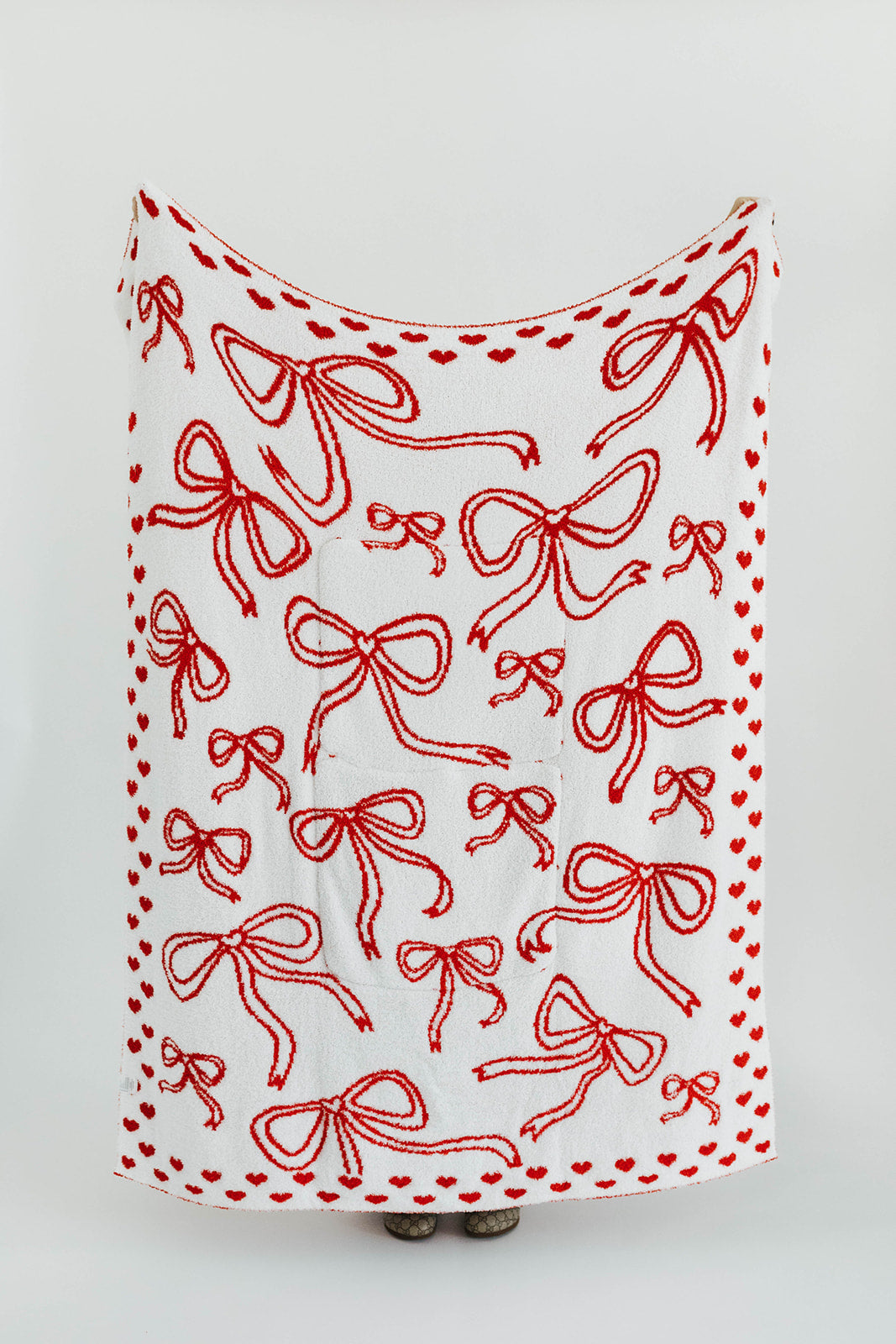 White blanket with red bow pattern on a white background