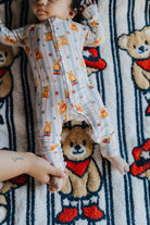 showing baby laying on the kid blanket with teddy pjs on