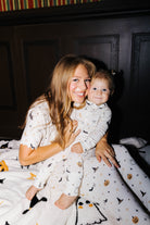 Adult and child in matching pajamas sitting on the Halloween Icon Print blanket