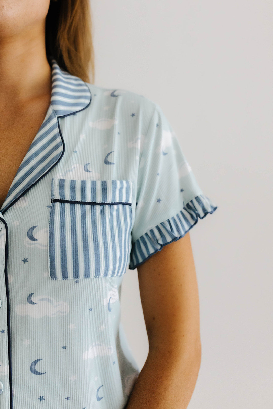 the cloud ruffle pajama top pocket and collar are blue and white striped 