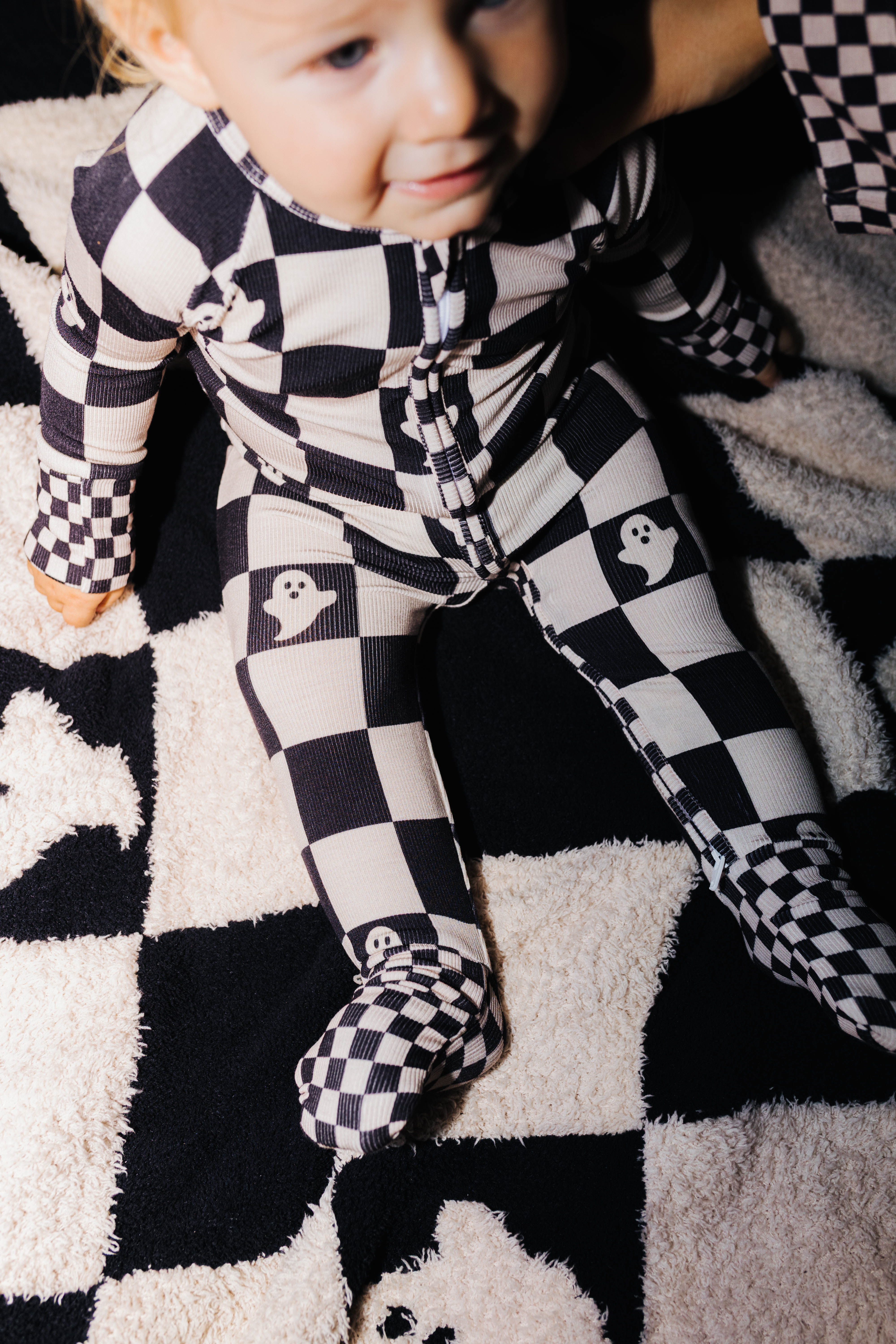 Close view of the zipper and collar on baby Ghost Check pajamas