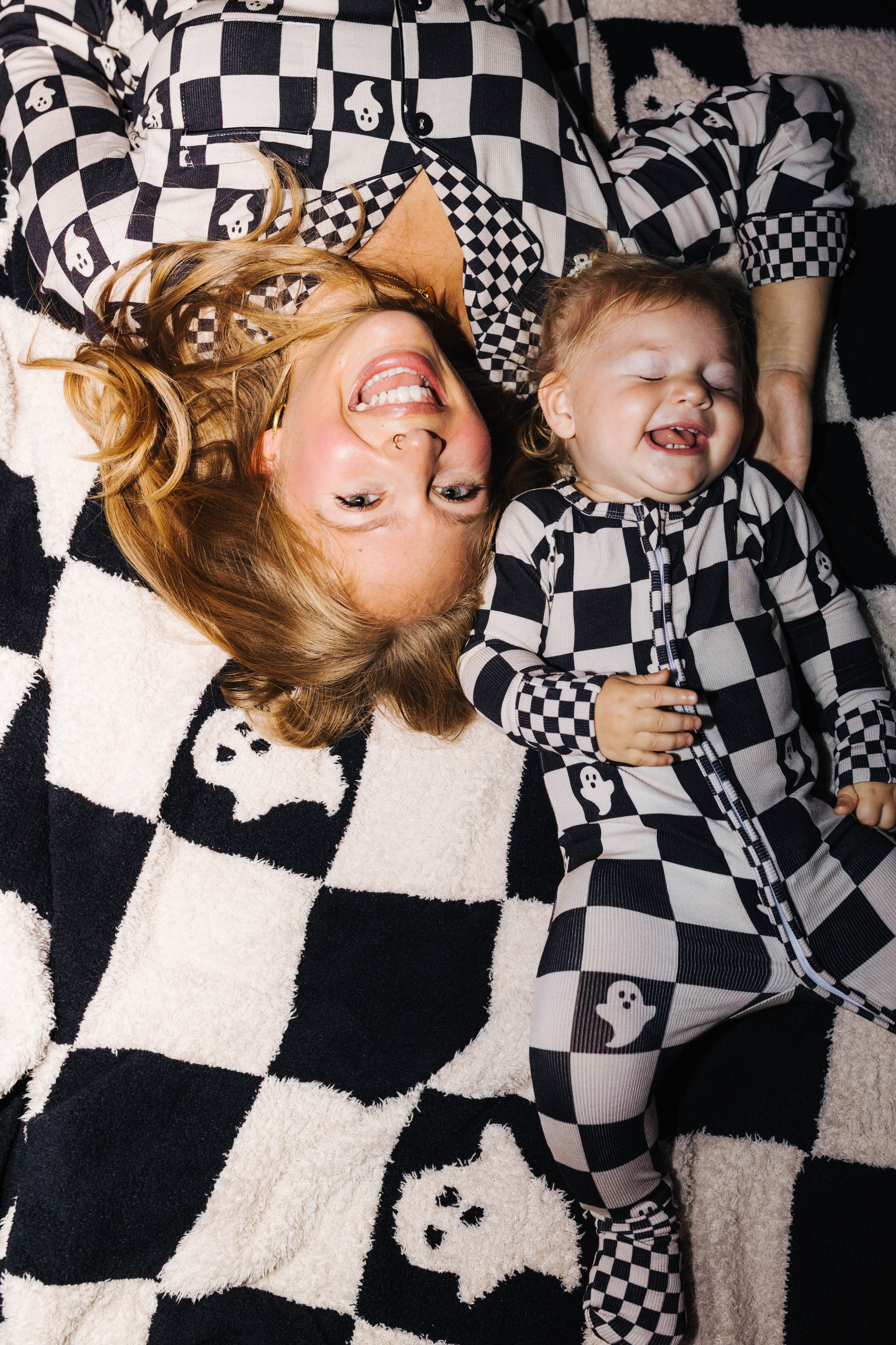 mom and her baby laying in matching pjs on matching blanket