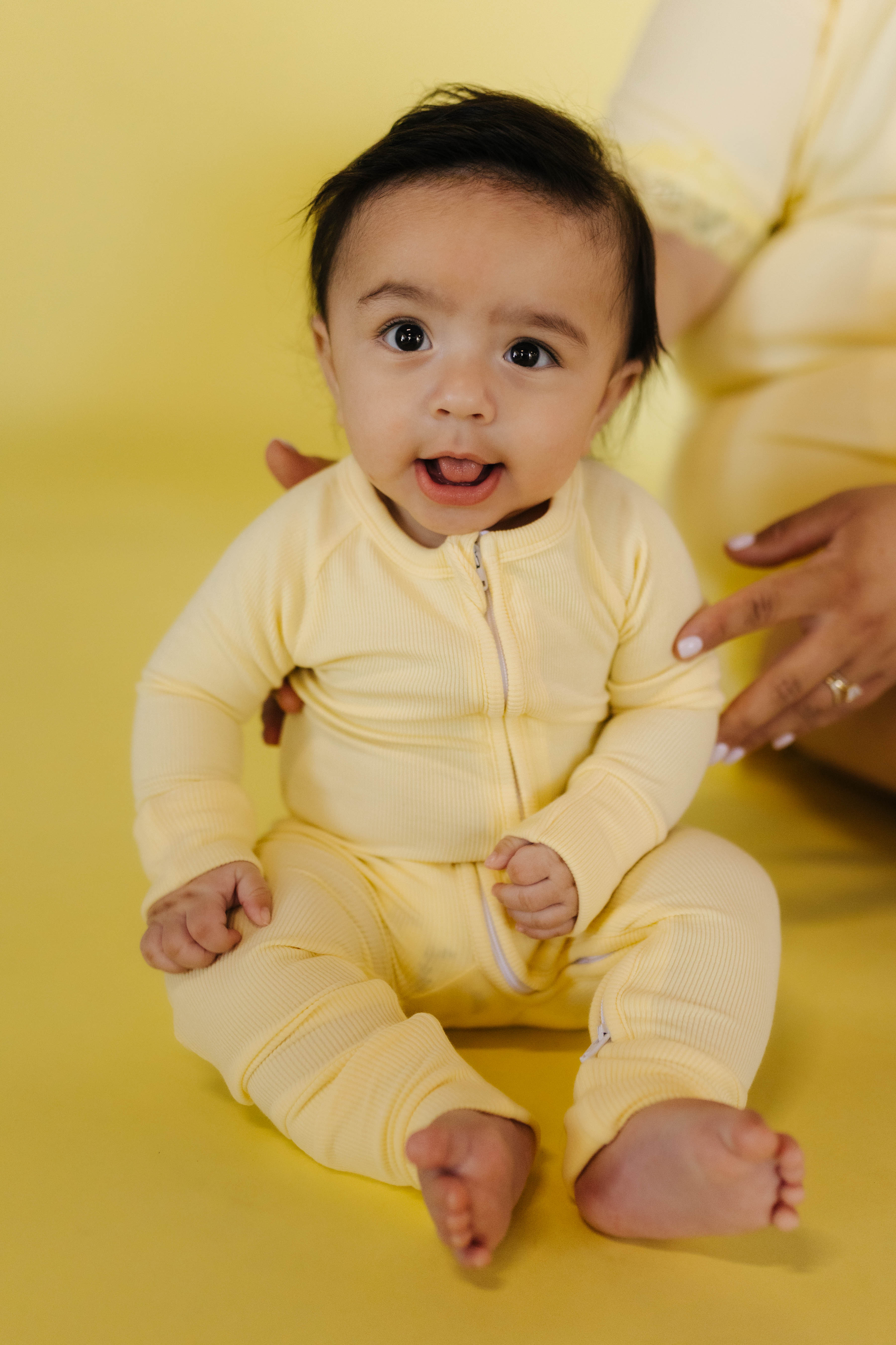 baby sitting in the butter yellow pjs on a butter yellow background