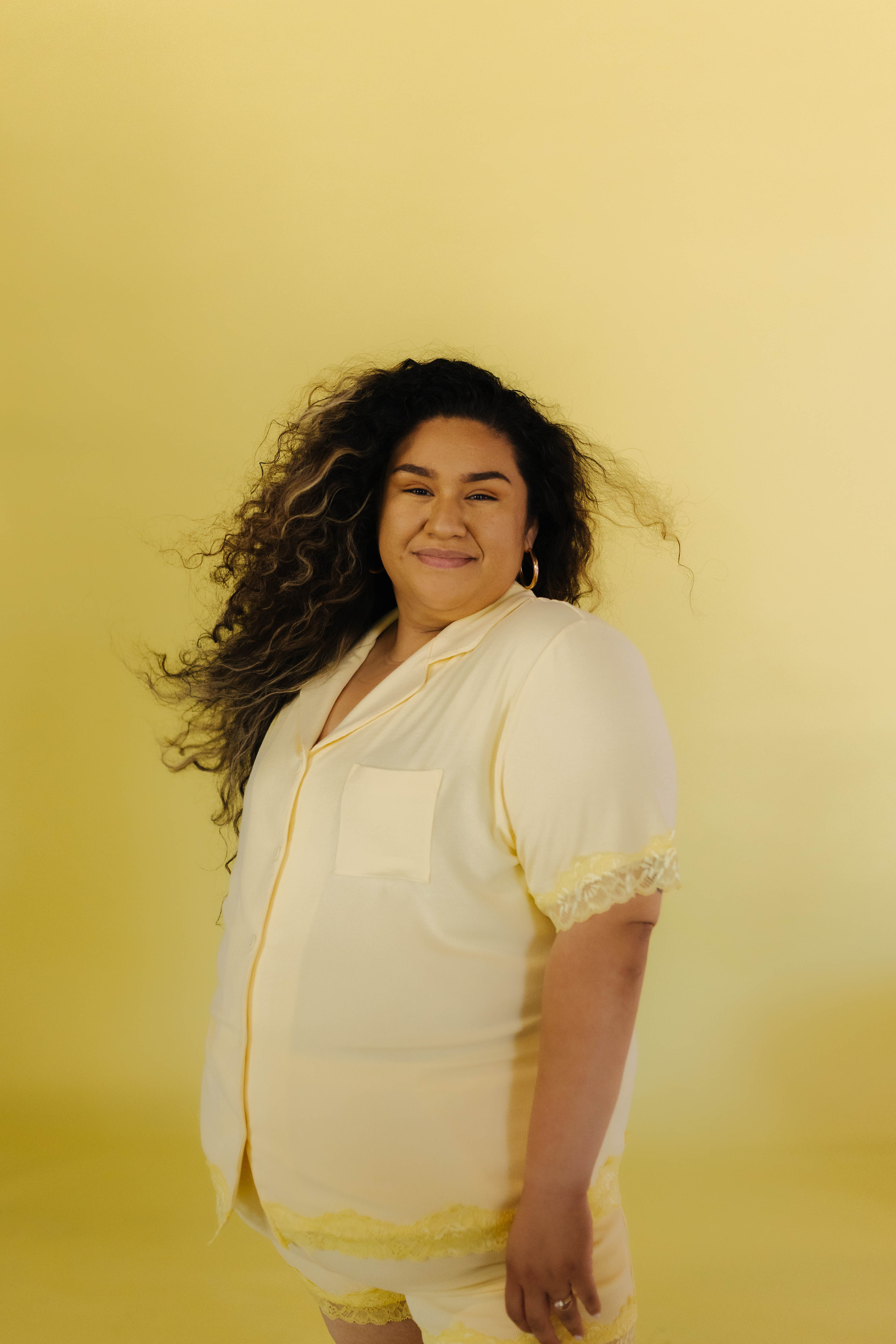 Perla modeling the 3xl in front of a yellow backdrops
