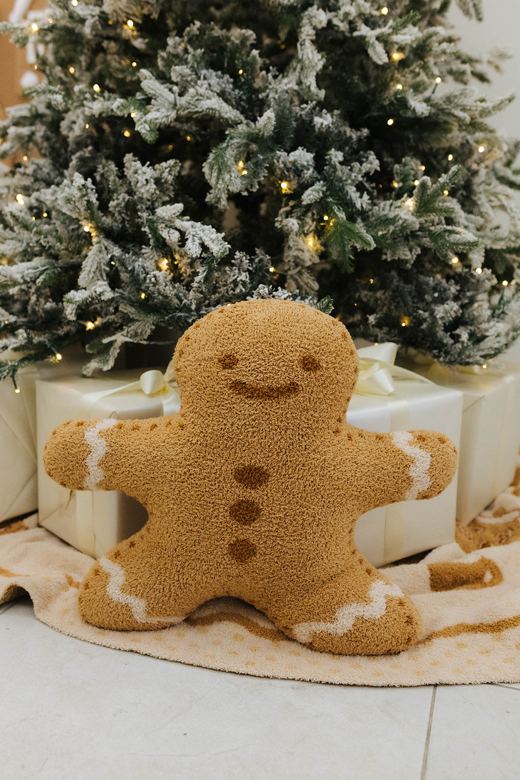 Gingerbread man decoration in front of a Christmas tree with lights.
