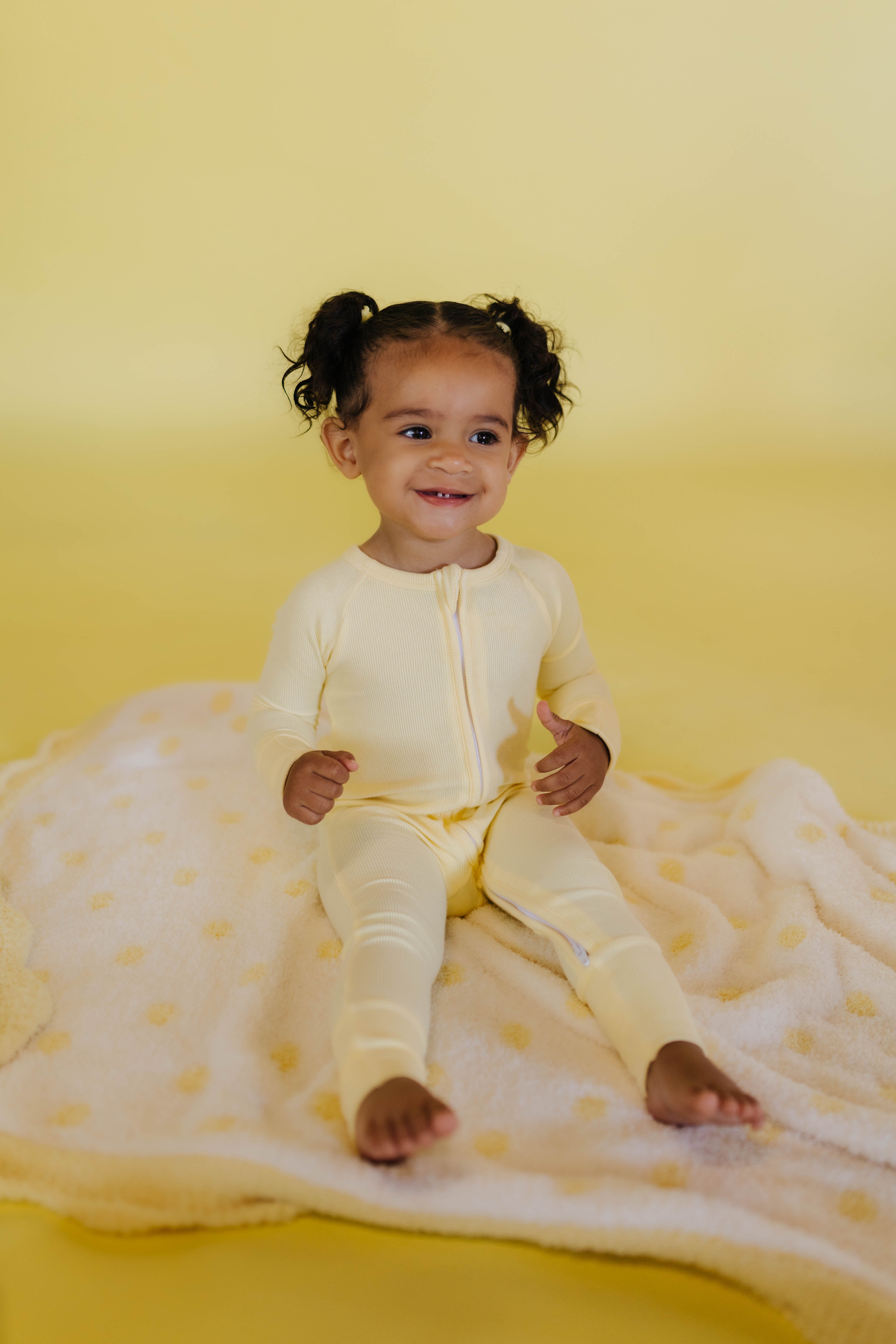 journiee sitting on the yellow polka kid blanket 